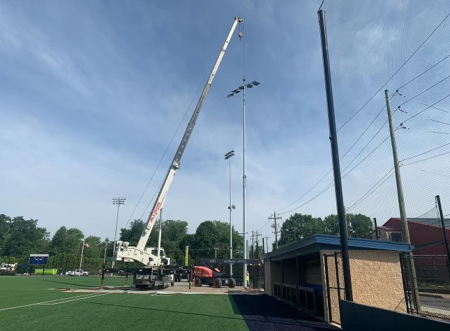 Construction crews working at Bruggeworth Field to install a new light system, which will allow for nighttime baseball games.