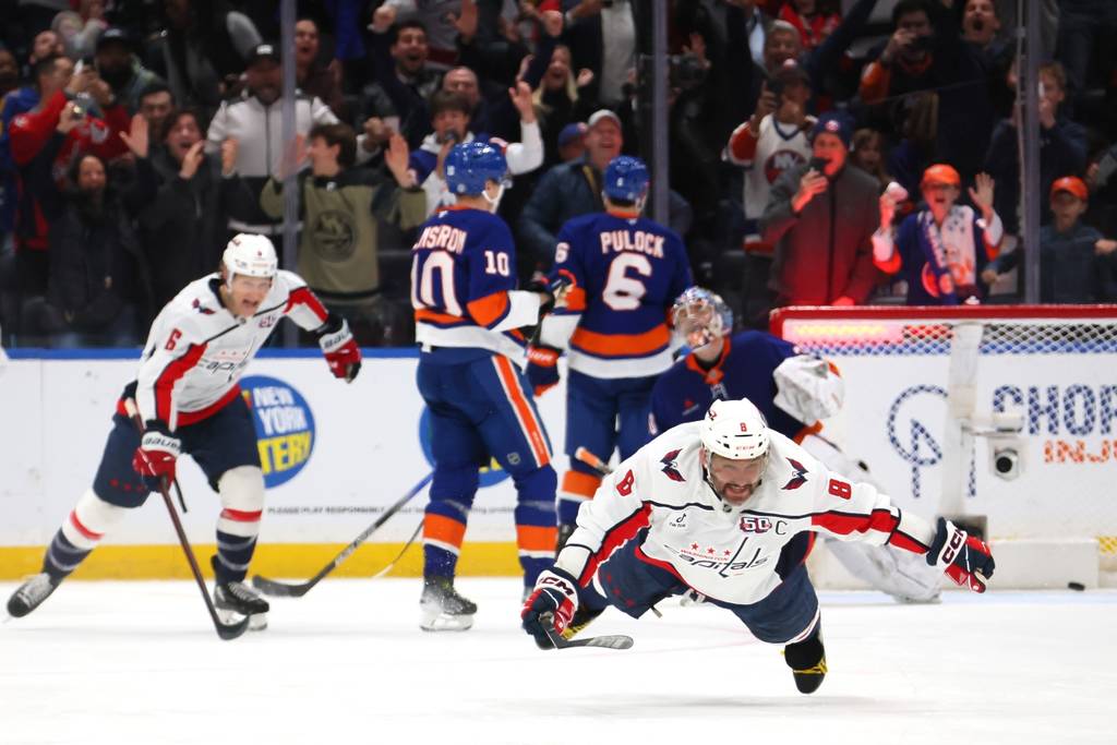 Alexander Ovechkin slides on the ice at UBS Arena after breaking Wayne Gretzky's all-time goal scoring record. 